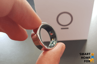 The Oura ring is being held in hand, and the packaging can be seen in the background