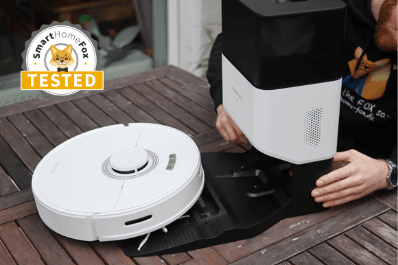 Roborock Q7 Max+ robot vacuum cleaner stands on the table with the suction station during testing.