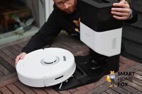 Roborock Q7 Max+ robot vacuum cleaner stands on the table with an emptying station during the test.