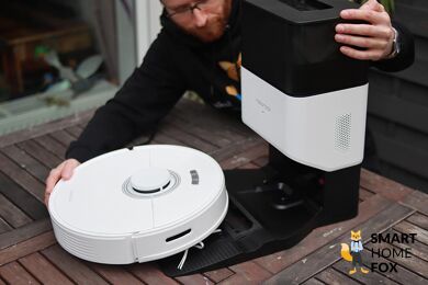 Roborock Q7 Max+ robot vacuum cleaner stands on the table with an emptying station during the test.