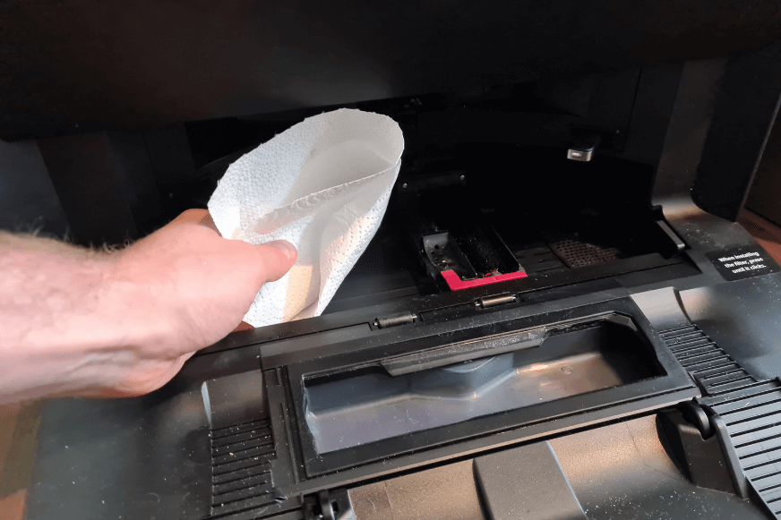 The Roborock S7 MaxV Ultra Station's mop tray is wiped clean with a cloth.