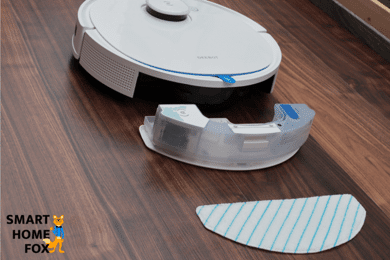 The water tank and the mop lie on the floor behind the Ecovacs Deebot T9.